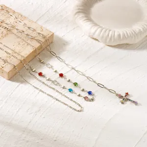 Silver layered necklace set featuring colorful rhinestones and a cross pendant detail