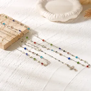 Silver-tone layered necklaces with colorful rhinestones and cross pendant details