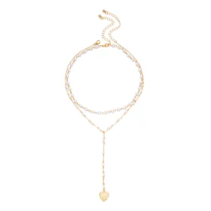 Close-up detail of a double-layered gold-tone chain necklace with pearls and heart pendant