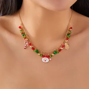Vista detallada de un collar de Navidad dorado con dijes de Papá Noel y muñeco de nieve.