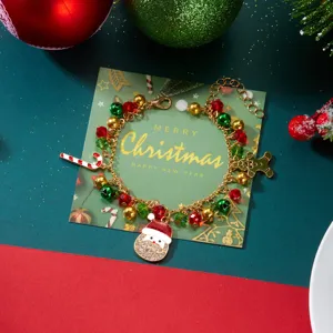 Primer plano de una festiva pulsera de Navidad con colgantes de Papá Noel y bastones