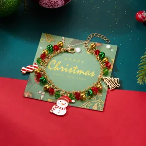 Primer plano de pulsera navideña con dijes de muñeco de nieve y bastón de caramelo festivo