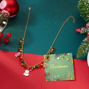 Vista detallada de collar dorado de Navidad con colgantes de muñeco de nieve y árbol festivo