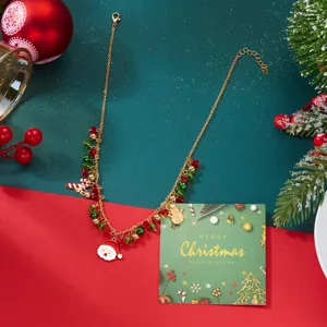 Vista detallada de un collar de Navidad dorado con Papá Noel y cuentas de cristal