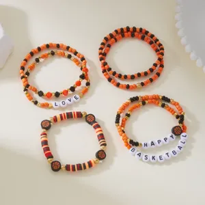 Detailed macro view of orange and black basketball theme beaded bracelets with letter charms