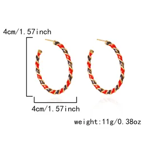 Close-up detail of 4cm twisted hoop earrings featuring red and black enamel drip finish
