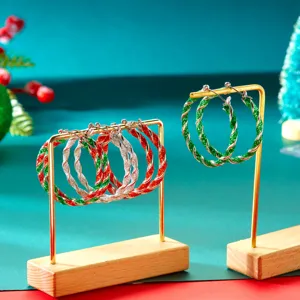 Close-up of Christmas red and green twisted hoop earrings with glitter finish