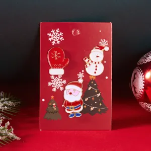 Dettaglio di tre spille natalizie con Babbo Natale, pupazzo di neve e guanto rosso