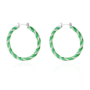 Detailed view of silver twisted hoop earrings with green glitter enamel finish.