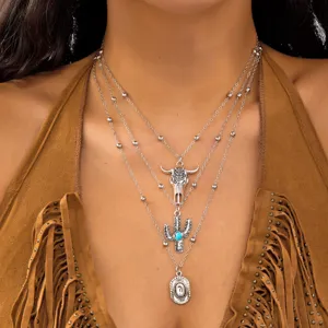 Detail of Western style layered necklace with bull head and turquoise cactus pendants.