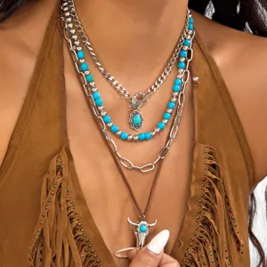 Close-up detail of a Western cowboy style layered necklace set with turquoise and bull head