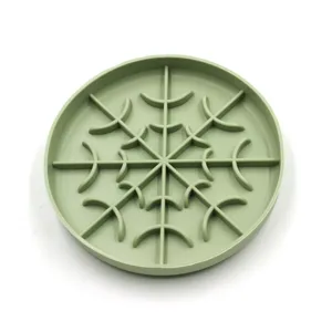 Gros plan sur l'intérieur du bol anti-glouton en silicone vert, design de grille pour alimentation.