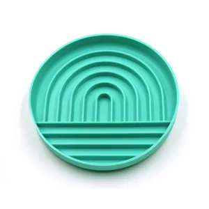 Durable teal circular silicone pet lick mat featuring a rainbow slow feeder pattern
