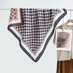 Gedetailleerd overzicht van de dubbelzijdige geruite sjaal met contrasterende kleuren en zachte textuur.
