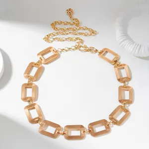 Detailed view of a vintage gold metal waist chain belt with textured rectangular links