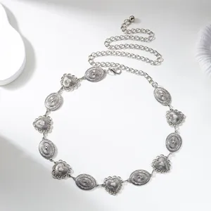 Detailed view of a vintage silver metal waist chain with carved heart and oval pendants