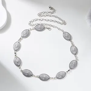 Detailed view of vintage silver body chain with intricate oval relief engravings