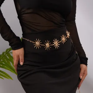 Close-up of vintage gold sunburst pendant waist chain styled on a black midi dress