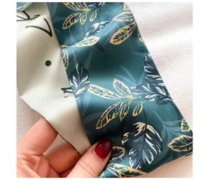 Gedetailleerde close-up van een stijlvolle groene zijden sjaal lint voor tas en haar.