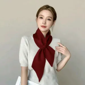 Gedetailleerd overzicht van de stijlvolle gebreide kruissjaal, zachte textuur, elegant accessoire.