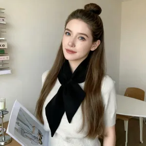 Mooi gedetailleerd shot van een elegante zwarte gebreide kruissjaal met witte top.