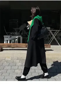 Dettaglio outfit stile strada invernale moda coreana con cappotto nero e sciarpa.
