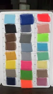 Detailed view of crinkled cheese cloth fabric color swatch card with various shades.