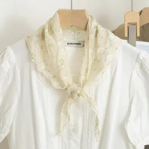 Detail van een bloemige driehoekige sjaal, lichtgewicht geplooide stof voor vrouwen.