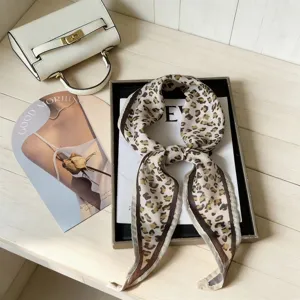Detailopname van vintage luipaardprint rhombe sjaal, prachtig gestyled op wit houten oppervlak.