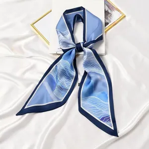 Gedetailleerd overzicht van smalle zijden sjaal met blauwe golfprint, elegante lint voor tassen.