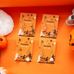 Primer plano de pendientes de Halloween con dijes de fantasma, calabaza y estrella.