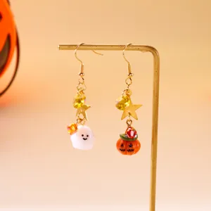 Detalle de los pendientes colgantes de Halloween con fantasma y calabaza en soporte dorado