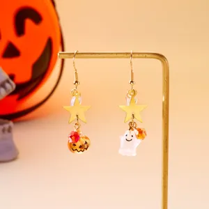 Primer plano detallado de pendientes asimétricos de Halloween con fantasma y calabaza