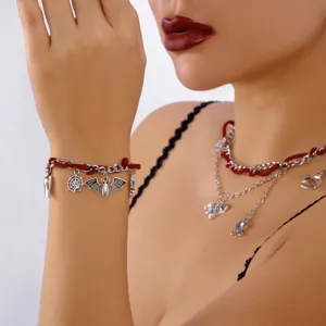 Halloween Armband und Halskette Set mit Fledermaus und Spinne Anhängern auf roter Schnur.