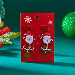 Detailed view of festive Santa Claus acrylic earrings featuring red glitter hearts on card