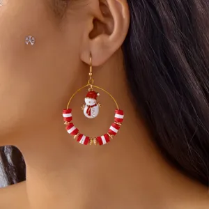 Nahaufnahme eines weihnachtlichen Ohrrings mit Schneemann-Anhänger und Fimo-Perlen