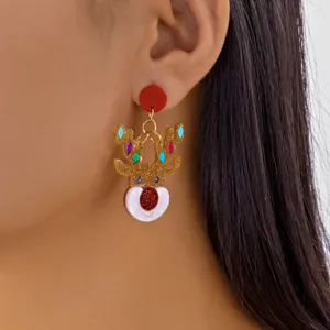 Detail view of golden glitter acrylic reindeer earrings for Christmas worn on ear.