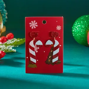 Close-up detail of festive red and white candy cane acrylic earrings with glitter hearts
