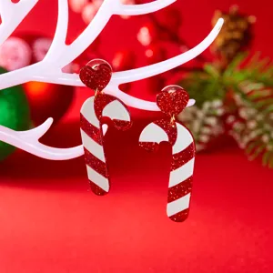 Close-up of festive red and white acrylic candy cane earrings with glitter hearts.