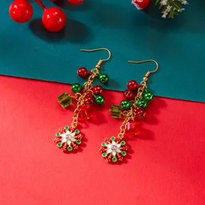 Detailansicht festlicher Weihnachtsohrringe mit roten und grünen Glocken und Schneeflocken