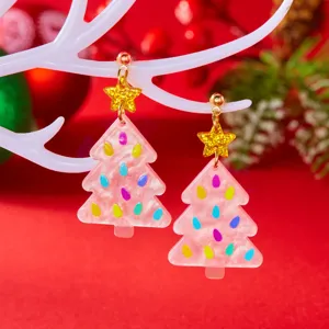 Close-up of pink acrylic Christmas tree earrings with gold glitter star studs