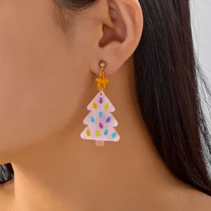 Close-up shot of a model wearing a pink acrylic Christmas tree earring with a gold star