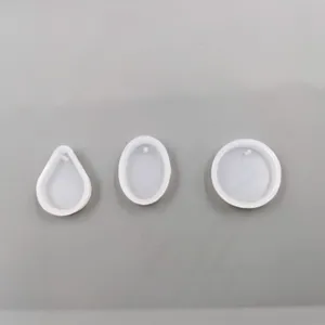 Primo piano dettagliato di stampi in silicone per ciondoli in resina, forme geometriche varie.