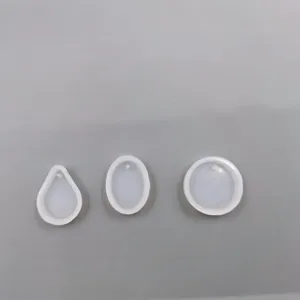 Vista dettagliata di stampi in silicone trasparente per ciondoli con fori per resina.