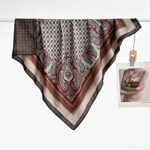 Gedetailleerde close-up van de vierkante zijden sjaal met verfijnd paisley patroon en textuur.
