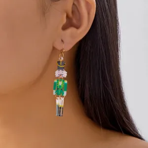 Close-up of a festive Christmas nutcracker acrylic earring worn on an ear