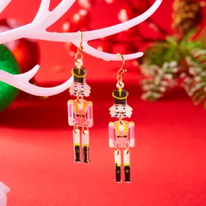 Close-up view of festive pink nutcracker acrylic earrings hanging on a white branch