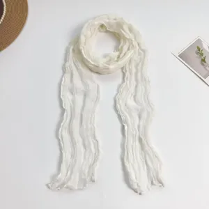 Gedetailleerd uitzicht van een witte geplooide kreukelsjaal, lichte katoenmix stola voor dames.