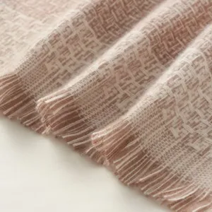 Close-up detail shot of soft woven plaid winter scarf featuring elegant fringe trim texture.
