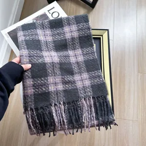 Gedetailleerde close-up van de winterse geruite sjaal met zachte textuur en mooie franjes.